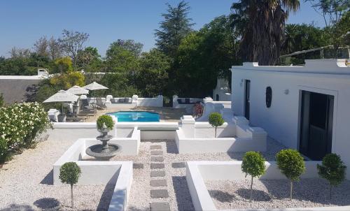 a backyard with a swimming pool and a house at De Kloof Heritage Estate and Wellness in Swellendam