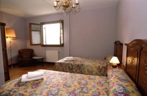 a hotel room with two beds and a chair at Agroturismo Orortegi in Aia