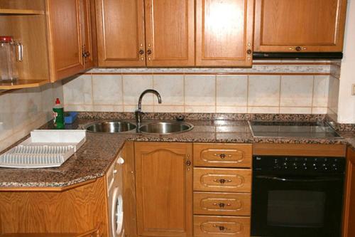 a kitchen with wooden cabinets and a sink at Ramonet in Son