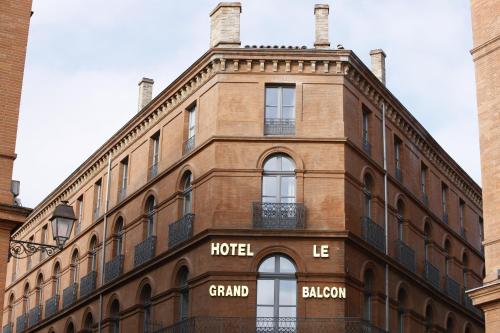 un gran edificio de ladrillo con un cartel de hotel en Le Grand Balcon Hotel, en Toulouse