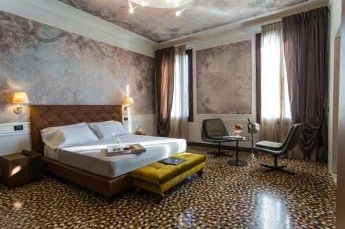 um quarto de hotel com uma cama e uma cadeira em Riva del Vin BOUTIQUE HOTEL em Veneza