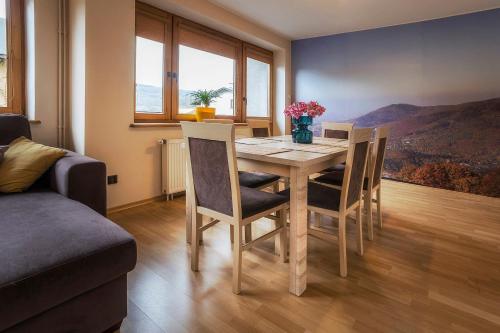 a dining room with a table and chairs with a view at Bastówka Apartamenty in Ustroń