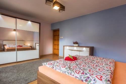 sypialnia z dużym łóżkiem z czerwonymi poduszkami w obiekcie Bastówka Apartamenty w Ustroniu
