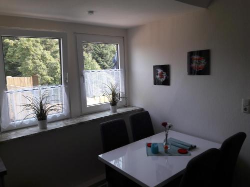 a dining room with two windows and a table at Stefanie in Heide