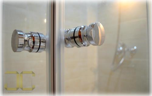 a glass shower door with a knob on it at Country Apartment by JC in Porto