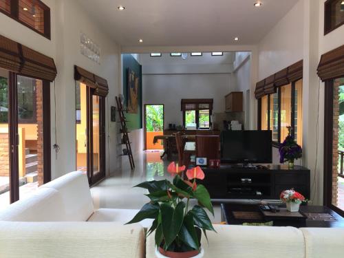 a living room with a white couch and a tv at Silent Palm Samui in Taling Ngam Beach
