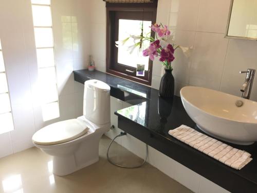 a bathroom with a white toilet and a sink at Silent Palm Samui in Taling Ngam Beach
