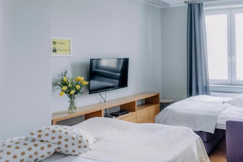 a hotel room with two beds and a television at APARTEL Plac Zbawiciela in Warsaw