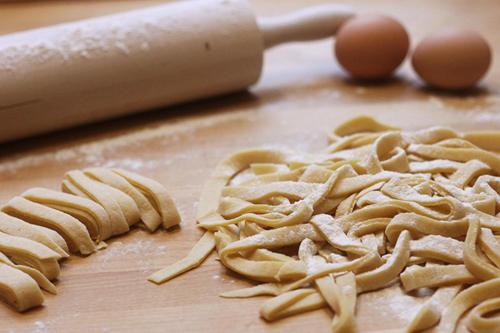 a pile of uncooked pasta and eggs on a cutting board at B&B I Coppi in San Gimignano