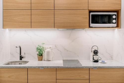 a kitchen counter with a sink and a microwave at APARTEL Plac Zbawiciela in Warsaw