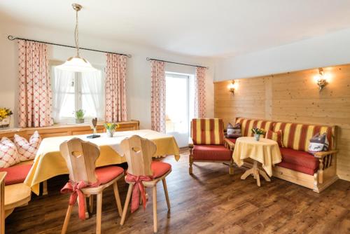 a dining room with a table and chairs and a couch at Ferienwohnung - Café Mali in Bad Hindelang