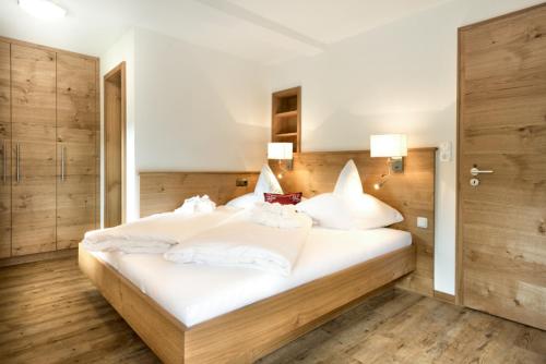 a bedroom with a large bed with white sheets and pillows at Ferienwohnung - Café Mali in Bad Hindelang