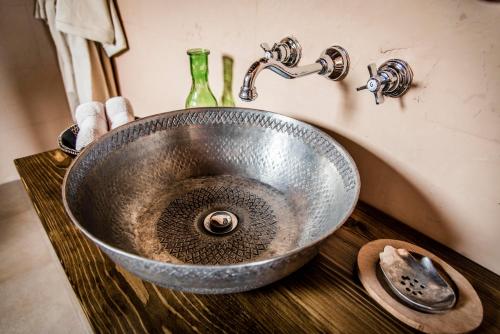 a metal sink on top of a wooden counter at Dar Camelia in Soûr