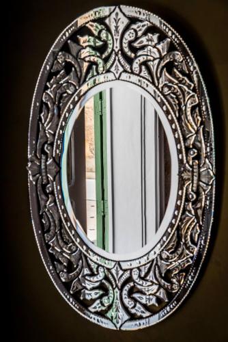 a mirror with an ornate frame on a wall at Dar Camelia in Soûr