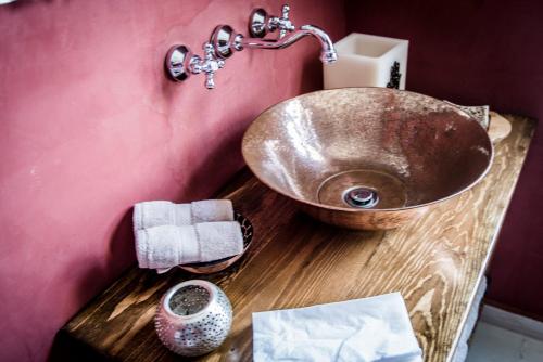a bathroom with a copper sink on a wooden counter at Dar Camelia in Soûr