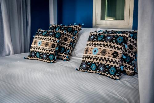 a bed with four pillows on top of it at Dar Camelia in Soûr