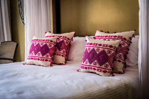 a bed with several pillows on top of it at Dar Camelia in Soûr