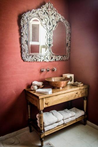 a bathroom with a sink and a mirror on a wall at Dar Camelia in Soûr