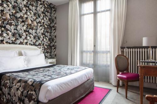 a hotel room with a bed and a window at Hôtel Regent's Garden - Astotel in Paris