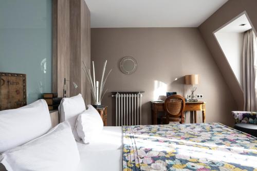 una camera con letto, scrivania e sedia di Hôtel Regent's Garden - Astotel a Parigi