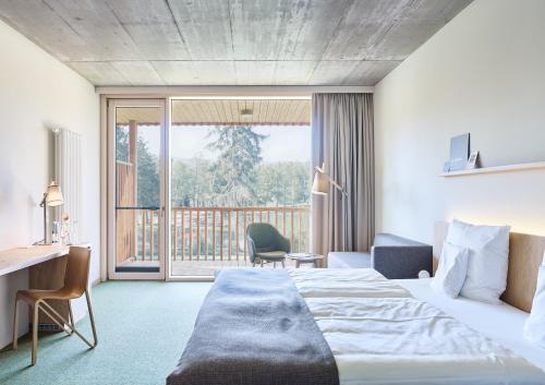 a hotel room with a bed and a balcony at Waldstrand-Hotel Großschönau in Großschönau