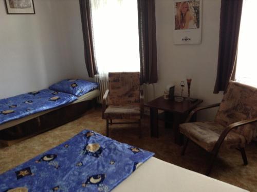 a room with two beds and a table and chairs at AT Pension in České Budějovice