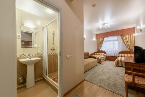 ein Bad mit einer Dusche und einem Waschbecken in einem Zimmer in der Unterkunft Nord House in Sankt Petersburg