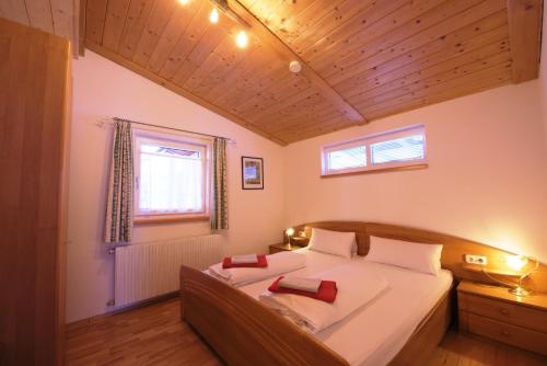 a bedroom with a bed with two red pillows on it at Appartements Oberdorfer in Landeck
