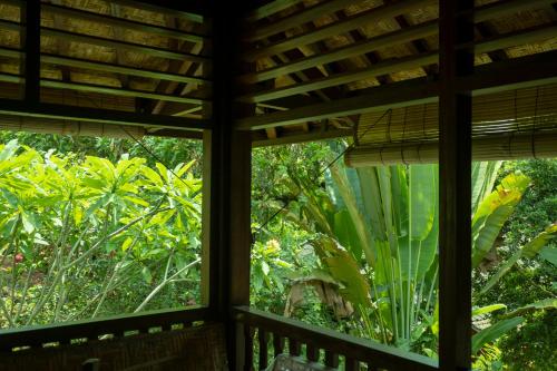 a room with a window looking out into a garden at Murni's Houses & Spa in Ubud