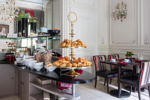 a kitchen with a table with a tray of bread at Hôtel Regent's Garden - Astotel in Paris