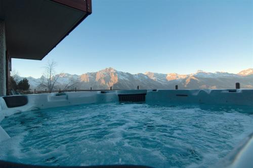 a hot tub with a view of the mountains at Chalet Riquet - Ski/in-out - Jacuzzi in Nendaz