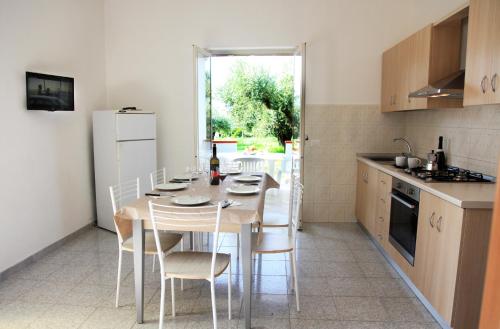 a kitchen with a table and chairs in a kitchen at Case Vacanze Sangeni in Capo Vaticano
