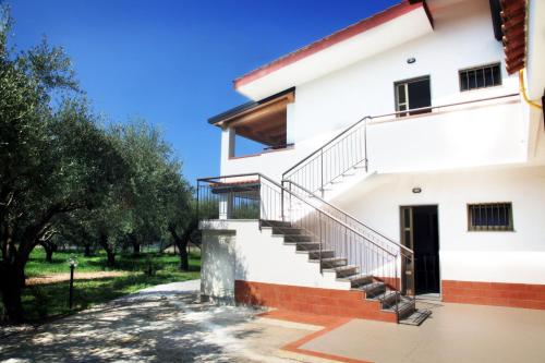 a white house with stairs and trees at Case Vacanze Sangeni in Capo Vaticano
