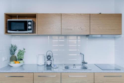 a kitchen with a sink and a microwave at APARTEL Plac Zbawiciela Studio in Warsaw