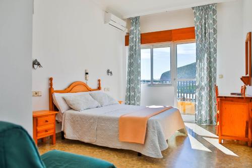 a bedroom with a bed and a large window at Hotel Iberico in Castell de Ferro