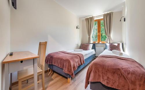 a bedroom with two beds and a desk and a window at Apartamenty EverySky Nadrzeczna 3E-3D in Karpacz