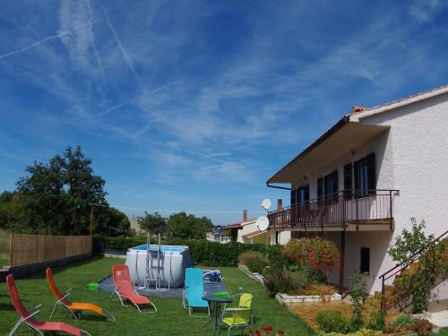a yard with chairs and a table and a house at Comfortable and quiet apartment in Istria with privacy in Šajini