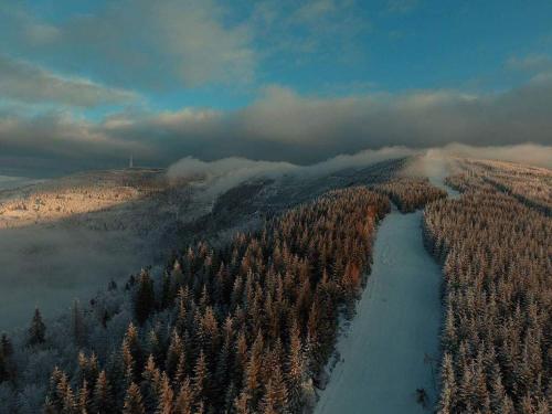 an aerial view of a snow covered forest with a river at Mała Osada domki z jacuzzi przy gondoli in Szczyrk