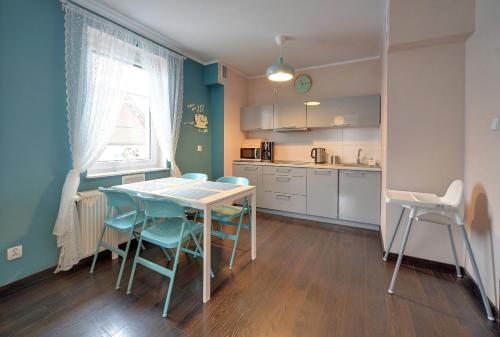 eine Küche mit einem Tisch und Stühlen im Zimmer in der Unterkunft Apartamenty Sun Seasons 24 - Villa Avangarda in Szklarska Poręba