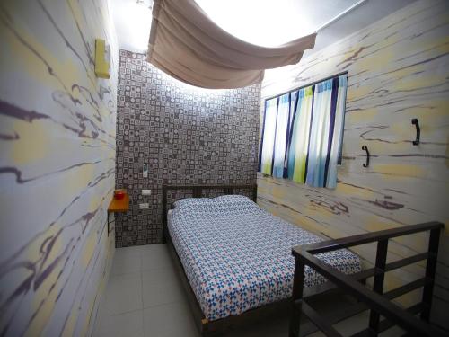 a small bedroom with a bed in a room with a wall at Sha Feng Lu Dian in Magong