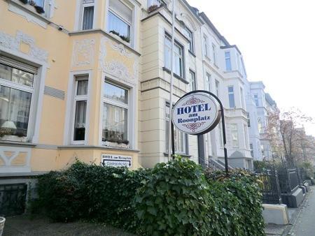 Hotel Am Roonplatz في بون: لافته للفندق امام مبنى
