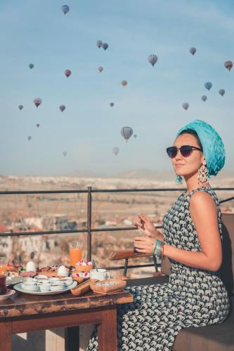 a woman sitting at a table with food on it at Seki Cave Suites in Goreme
