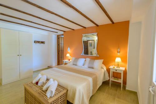 a bedroom with a large bed and a mirror at Casa Jardín del Olivar con Piscina privada in Alcaucín
