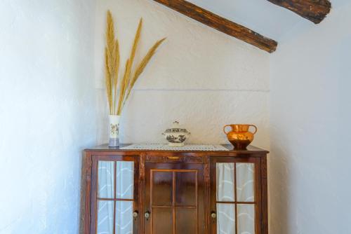 a wooden cabinet with two vases on top of it at Casa Jardín del Olivar con Piscina privada in Alcaucín