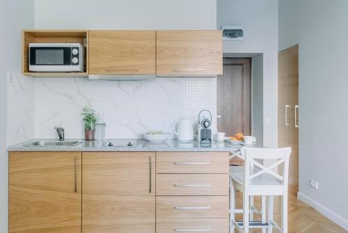 eine Küche mit Spüle und Mikrowelle in der Unterkunft APARTEL Plac Unii Lubelskiej Studio in Warschau