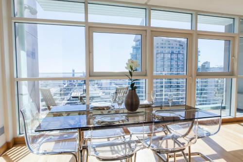 a dining room with a glass table and chairs at RENT4REST LISBON PARQUE DAS NAÇÕES 17Th FLOOR RIVER VIEW in Lisbon