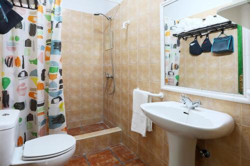 ein Bad mit einem Waschbecken, einem WC und einer Dusche in der Unterkunft Marody House Vacacional in Granadilla de Abona