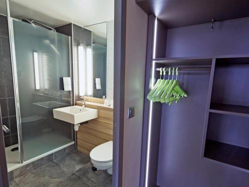 ein lila Badezimmer mit einem WC und einem Waschbecken in der Unterkunft Campanile Dijon Nord - Toison D'or in Dijon