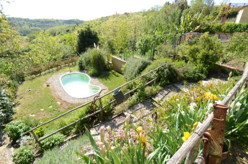 a garden with a swimming pool and a fence at Al Colle Di Lari in Lari