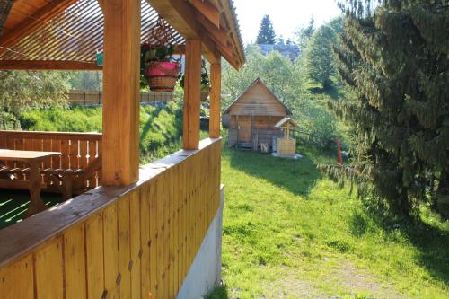 a porch of a wooden house with a picnic table and a cabin at Arnica Montana in Arieşeni